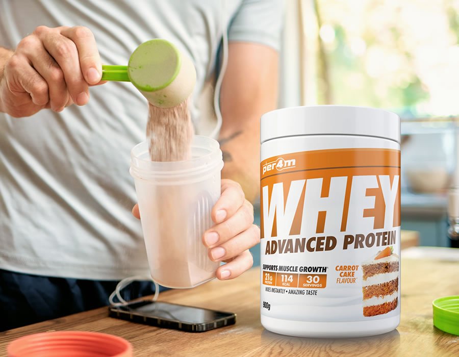 Closeup of one caucasian man pouring a scoop of whey protein powder to a health shake for energy for training workout in a kitchen at home.